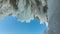 Icicles of various sizes appeared on the roof of a stone grotto in the rock.