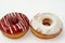 Icing powdered confectioners\' sugar and Strawberry flavored ring donut, A glazed, yeast raised, American style ring doughnut