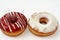 Icing powdered confectioners\' sugar and Strawberry flavored ring donut, A glazed, yeast raised, American style ring doughnut