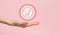 Icon of human embryo rests on white female hand. Close-up, pink  background. The concept of the origin of the world