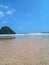 Iconic Banyuwangi (indonesia) Beach called Pantai Pulau Merah with blue sky and a uninhabited island. taken at May, 2023