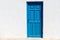 Iconic blue wooden door against clear white wall and colorful fl