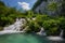 Iconic croatian waterfall flowing into an emeral pond under a blue summer sky