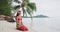 Iconic French Polynesia video of woman wearing traditional pareo and Bikini relaxing sitting down on a paradise beach on