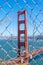 Iconic Golden Gate Bridge through a fence