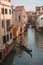 Iconic Gondola Gliding Through Serene Venice Canal - Classic Italian Waterway Scene
