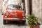 Iconic Italian orange Fiat car parked in traditional narrow street. Gubbio, medieval town.