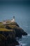 Iconic lighthouse with an arched tower on a rocky cliff overlooking the vast ocean