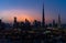 Iconic panorama at sunset of Burj Khalifa and Dubai Skyline as sun sets with blue and purple colors and other skyscrapers in the