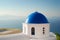 Iconic Santorini view of Caldera with blue dome of church