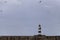 Iconic striped Seaham lighthouse on pier with clouds and sea walls