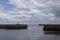 Iconic striped Seaham lighthouse on pier with clouds and sea walls