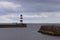 Iconic striped Seaham lighthouse on pier with clouds and sea walls