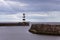 Iconic striped Seaham lighthouse on pier with sea walls