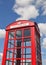 Iconic telephone box soaring into blue sky