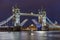 The iconic Tower Bridge in London at night, beautifully illuminated and with raised bascules