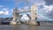 Iconic Tower Bridge in London, UK, scenic clouds, over the lifted bridge, and boat going under the bridge. 4k UHD