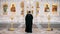 The Iconostasis inside an orthodox church. Video. Rear view of a priest standing in front of the icons with the faces of