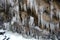 Icy crystals forming on forest water stream, winter landscape detail