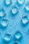 Icy cubes with shimmering water droplets on calm blue backdrop for a cool effect
