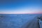 Icy landscape from a 4x4 car on a totally snowy road with tire tracks reaching to the horizon with a magical purple Icelandic