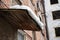 Icy snow lies on the wooden visor of an old brick apartment building in winter