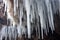 icy stalactites hanging from a cave roof