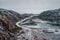 Icy winter road through the tundra hills in Teriberka. Amazing colorful Arctic landscape