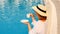 Ideal luxury life concept. morning female in straw hat drinks coffee near blue swimming pool