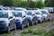 Identical blue cars stand in a row in a Parking lot or market for sale. View of the side mirrors, the Dealership. New car sales.