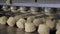 Identical pieces of sweet dough are formed using molding machine in bakery indoors.