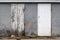 Identical two white wooden doors in different stages from brand new to dilapidated old with cracked boards and faded paint locked