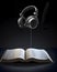 Idiom, Tuned into the Word, earphones plugged into book, created with Generative AI