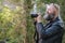 Idiosyncratic crazy artist with beard, holds a digital system camera