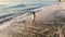 Idyllic aerial drone view of young thoughtful woman standing on beach watching scenic view of seascape during amazing