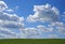 Idyllic countryside. Beautiful cumulonimbus clouds over a green meadow.