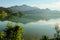 Idyllic foggy mountain landscape with a lake and mountains in the background