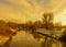 Idyllic golden impressionistic nature image of a river, riverside with promenade