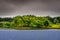 Idyllic island in the lake with green trees, Scotland