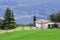 Idyllic Italian rural landscape green lawn, conifers, nebolshoy the white house with tiled roof in the background is lake Garda