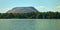 Idyllic lake with a strip of forest and the large spoil heap of a salt mine in the background