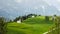 Idyllic landscape in the Alps with fresh green meadows and blooming flowers and d mountain tops in the background