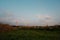 Idyllic landscape featuring red power lines extending across a rolling grassy field