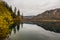 idyllic landscape with reflection from the pinetrees and mountains in the lake