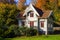 Idyllic little cottage with autumn colors on the trees