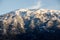 Idyllic Mountain and Forest Landscape on winter. Snowy slopes, rocks, cliffs and peaks. Panoramic view of mountain at sunset.