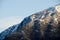 Idyllic Mountain and Forest Landscape on winter. Snowy slopes, rocks, cliffs and peaks. Panoramic view of mountain at sunset.