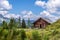 Idyllic mountain landscape in the alps: Mountain chalet, meadows and blue sky