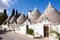 Idyllic narrow cobblestone street lined with traditional white-washed houses in Aberobelo, Italy