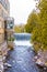 Idyllic natural landscape, waterfall of a river near building with balconies